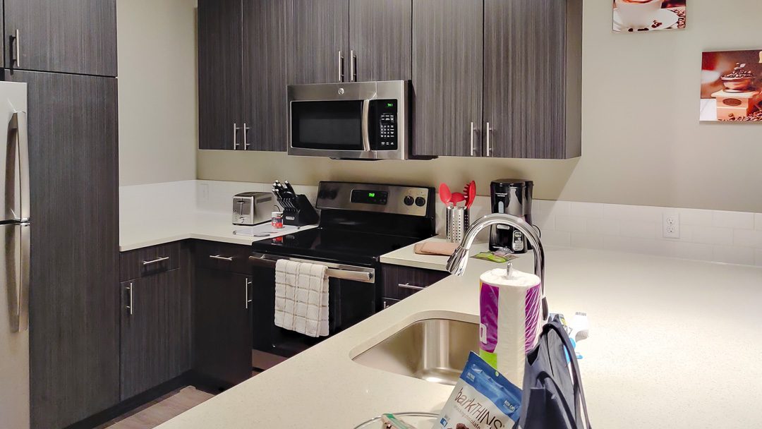 A kitchen with a wide counter, furnished with housewares including small appliances and